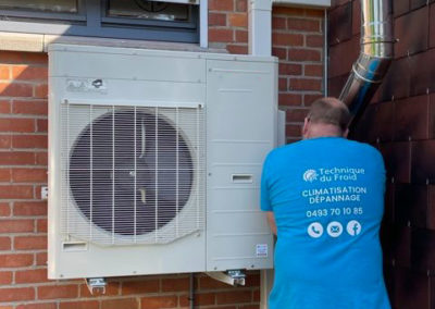 installation d'une clim sur le côté d'une maison par un professionnel en Belgique
